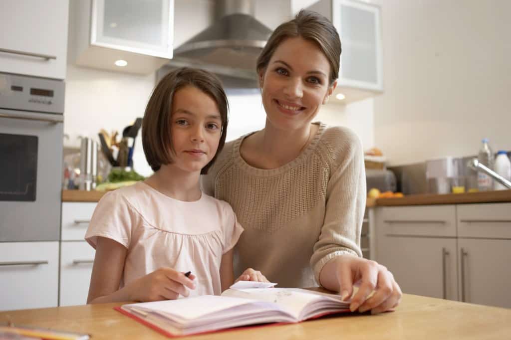 Mother and daughter working together with an exercise book